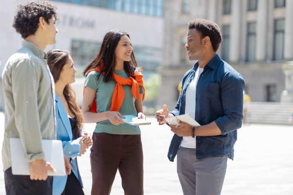 Group of smiling employees discussing pay transparency outside