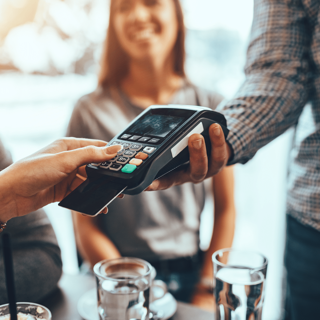 Restaurant patron picks up the check on a handheld payment device.